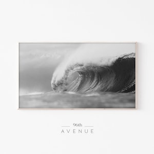 May include: A black and white photograph of a large wave crashing in the ocean. The wave is breaking and curling over itself, creating a dramatic and powerful image. The text "96th AVENUE" is printed below the image.