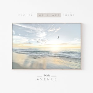 Könnte beinhalten: Ein digitaler Druck einer Strandszene mit einem goldenen Sonnenuntergang und Möwen, die am Himmel fliegen. Der Text "96th AVENUE" befindet sich am unteren Rand des Bildes.