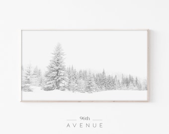 Könnte beinhalten: Ein Schwarzweißfoto eines schneebedeckten Waldes mit hohen Kiefern. Das Bild ist mit einem hellen Holzrahmen gerahmt. Der Text "96th AVENUE" ist unter dem Bild gedruckt.