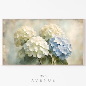 Op de afbeelding: Een aquarel schilderij van blauwe en witte hortensia's met een zachte, vintage esthetiek. De bloemen zijn in een boeket gerangschikt en de achtergrond is een lichtblauwe en witte waslaag.