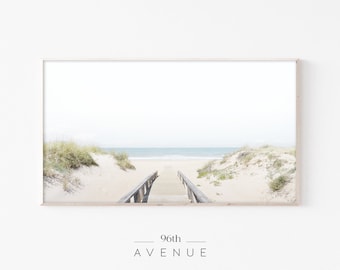 May include: A framed photograph of a wooden walkway leading to a beach with white sand and blue water. The sky is a light blue and the clouds are white. The text "96th AVENUE" is printed below the image.