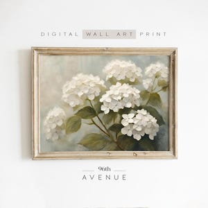 May include: A framed painting of white hydrangeas with green leaves against a light blue background. The painting is in a light wood frame and has the text "96th AVENUE" below it.