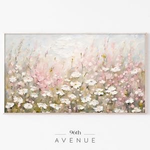 May include: A painting of a field of white and pink flowers. The flowers are painted in a soft, impressionistic style, with a focus on the delicate petals and the overall sense of light and airiness. The painting is framed in a simple white frame.