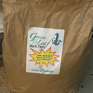 May include: A brown paper bag with a label that says "Green Leaf Worm Farm" and "SOIL BUILDER Feeds any Plant For 4 Months!"  The label also has a cartoon worm with a fork and a green leaf.
