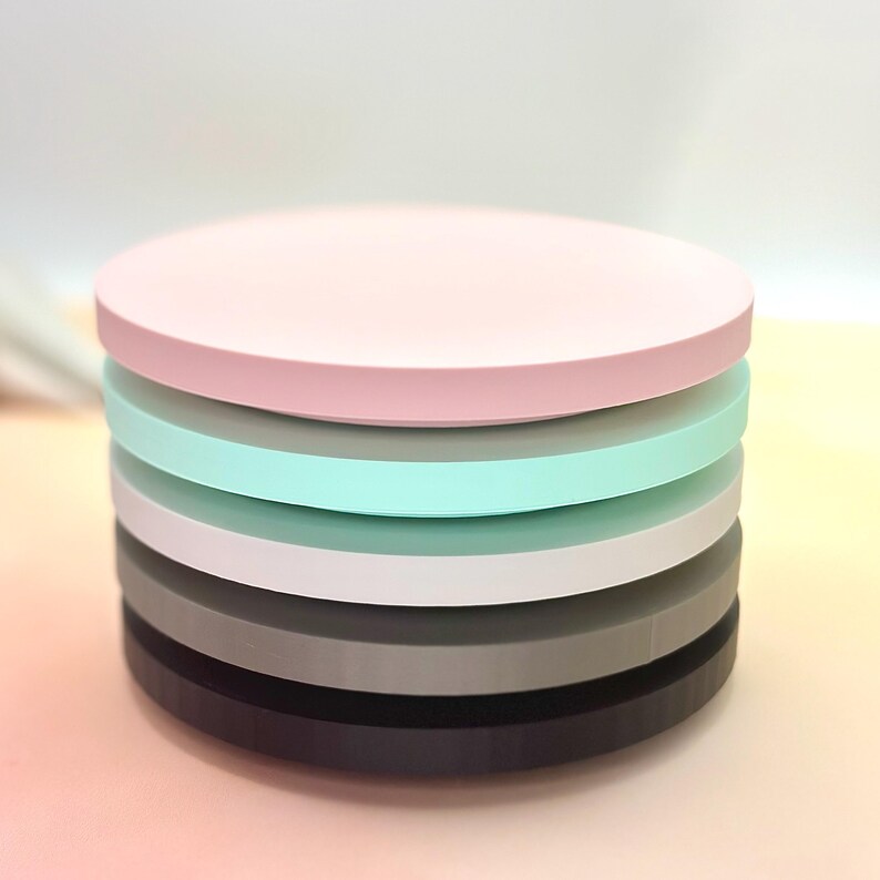 Pode incluir: Um conjunto de seis  tapetes redondos e coloridos. Os tapetes s&atilde;o em tons de rosa, cinza, branco e azul claro.