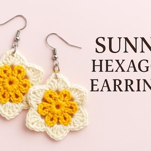 May include: A pair of handmade crochet earrings. Each earring features a white, six-petal flower with a bright yellow center. The earrings are suspended from silver-colored fish hook ear wires. The text "SUNNY HEXAGON EARRINGS" is displayed in brown.