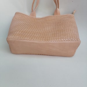 Op de afbeelding: Een lichtbeige geweven leren tote bag met twee handvatten.