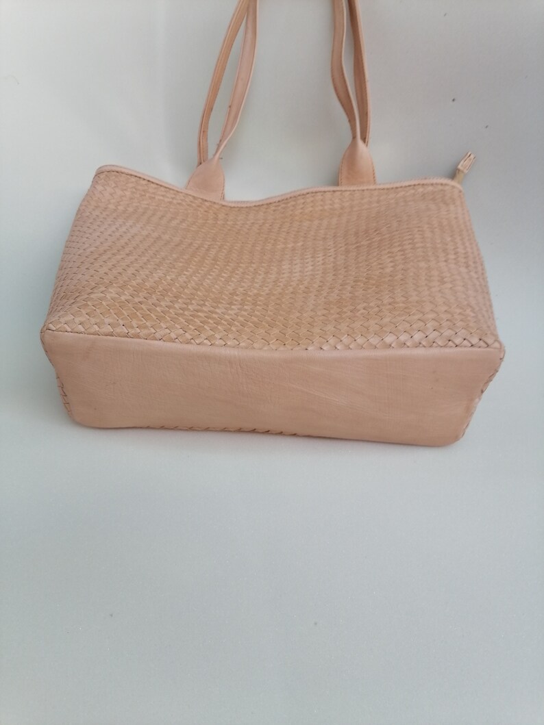 Op de afbeelding: Een lichtbeige geweven leren tote bag met twee handvatten.