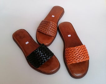 May include: Two pairs of woven leather sandals. One pair is brown with orange woven leather and the other pair is brown with black woven leather.