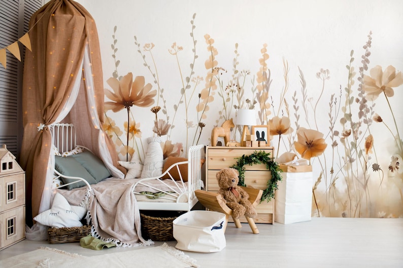 May include: A child's bedroom with a white bed, a canopy, and a floral mural. The room features a wooden dresser, a teddy bear, and decorative items. The color palette includes beige, brown, and white.
