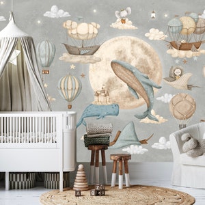 Puede incluir: Una escena de guarder&iacute;a caprichosa con un mural que representa una luna, globos aerost&aacute;ticos y ballenas en tonos pastel. Una cuna blanca, un dosel, un taburete de madera y mantas completan la escena. El ambiente es on&iacute;rico.