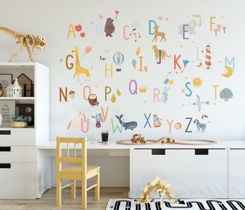 May include: A colorful alphabet wall decal set with animal illustrations, including a giraffe, bear, and zebra. The letters are in various pastel colors, creating a playful and educational theme for a child's room.