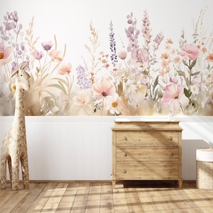 以下が含まれることがあります： パステルカラーの花柄壁画のある子供部屋のシーン。編み込みのキリンが木製のドレッサーの近くに立っています。ふた付きの編み込みバスケットが右側にあります。部屋には木の床と白い腰壁があります。