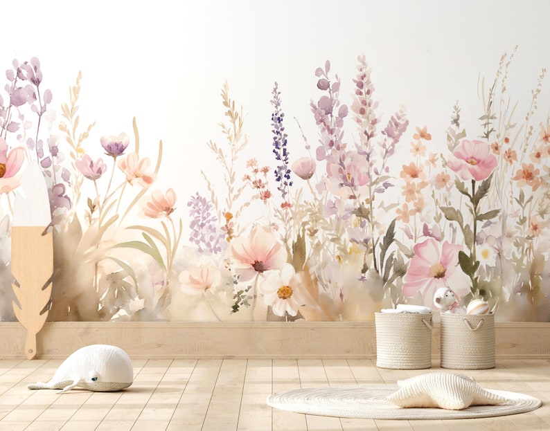 以下が含まれることがあります： ピンク、紫、ピーチの色合いの花が描かれた水彩画のフローラルウォールマウント。柔らかくニュートラルな背景に設置されています。部屋には木の床、2つの織りバスケット、装飾用の羽が含まれています。