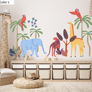 Op de afbeelding: Een muursticker set met een blauwe olifant, een gele giraf, een rode luipaard en twee rode papegaaien tussen groene palmbomen en donkerblauwe bloemen, inclusief diverse tropische planten in een vlakke, grafische illustratiestijl.
