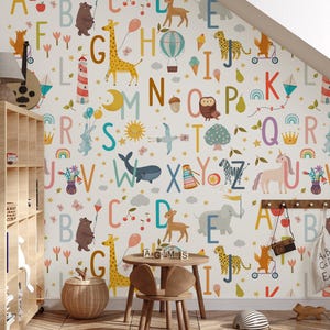 May include: A whimsical children's room with alphabet letters and animal illustrations on the wallpaper. The room features a wooden table and chairs, a wicker basket, and a toy train. The letters and animals are in various colors.