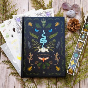 Può includere: Un diario con copertina rigida nera con un'illustrazione dettagliata di una scena notturna di foresta. La copertina presenta un serpente, una falena, felci e una luna crescente. Il testo "A Night in a Forest" è stampato sulla copertina.