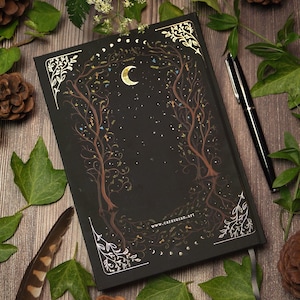 Witchy notebook "New Beginnings" with hand-painted fox illustration, gold foil moon phases and stars on black hardcover, A5 journal with Munken Pure paper. Back side view.