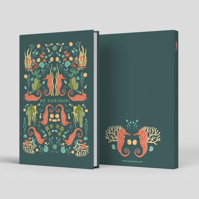 May include: A teal notebook with a colorful seahorse and coral design. The cover features the words "BE CURIOUS!" and the back has a matching seahorse and coral design. The notebook is a hardcover style.