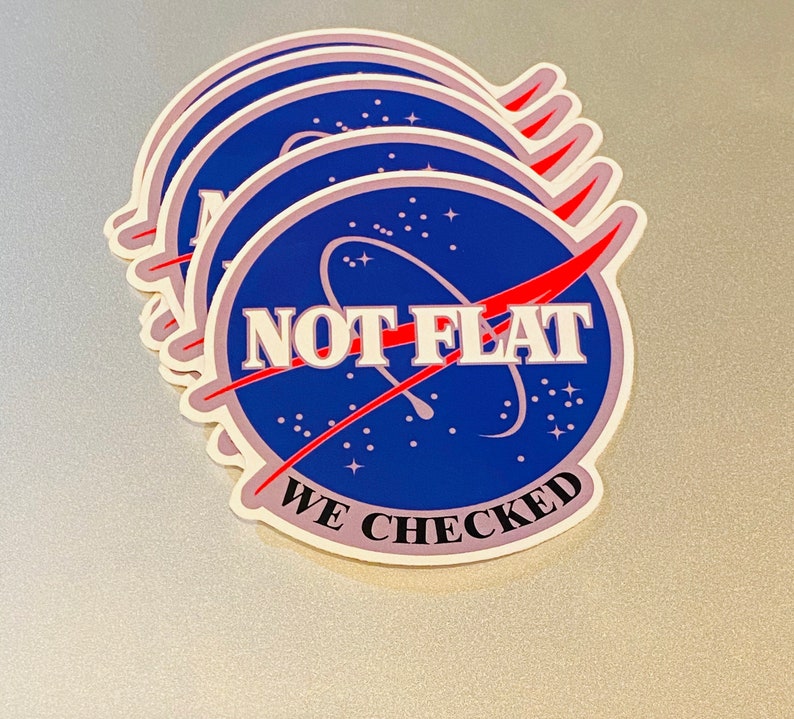 May include: A set of five stickers featuring a blue and white NASA-inspired logo with the text "NOT FLAT WE CHECKED" in red and white lettering.