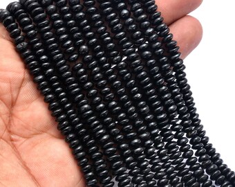 May include: A strand of black obsidian beads, each bead is round and slightly elongated, creating a textured look. The beads are strung together on a clear thread.