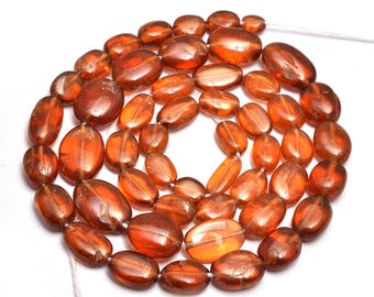May include: A strand of oval-shaped, orange-brown gemstone beads. The beads are smooth and polished, with a slight sheen.