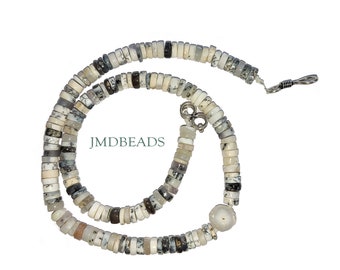 May include: A necklace composed of small, flat, circular beads in shades of white, gray, and black with dendritic patterns. The strand features a single larger, round, translucent bead and a silver-toned metal clasp. The text JMDBEADS is visible.