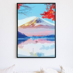 Puede incluir: Una pintura que representa el monte Fuji con su reflejo en un lago. La monta&ntilde;a est&aacute; cubierta de nieve y el lago est&aacute; rodeado de &aacute;rboles con hojas rojas.