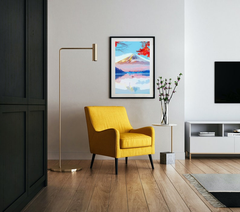 Puede incluir: Un sill&oacute;n amarillo con marco negro se encuentra frente a una impresi&oacute;n enmarcada de una escena de monta&ntilde;a con un lago y &aacute;rboles rojos. La impresi&oacute;n est&aacute; en una pared blanca con una l&aacute;mpara de pie y un jarr&oacute;n de flores en una mesa auxiliar.