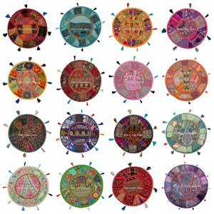 May include: A collection of round floor cushions with intricate patchwork designs. Each cushion features a unique color palette, including reds, blues, greens, and purples, with decorative tassels around the edges. The cushions appear to be approximately 24 inches in diameter.