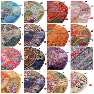 May include: A collection of colorful, round floor cushions with patchwork designs. Each cushion features a unique combination of fabrics in shades of blue, green, red, pink, orange, purple, and gold, with decorative tassels.