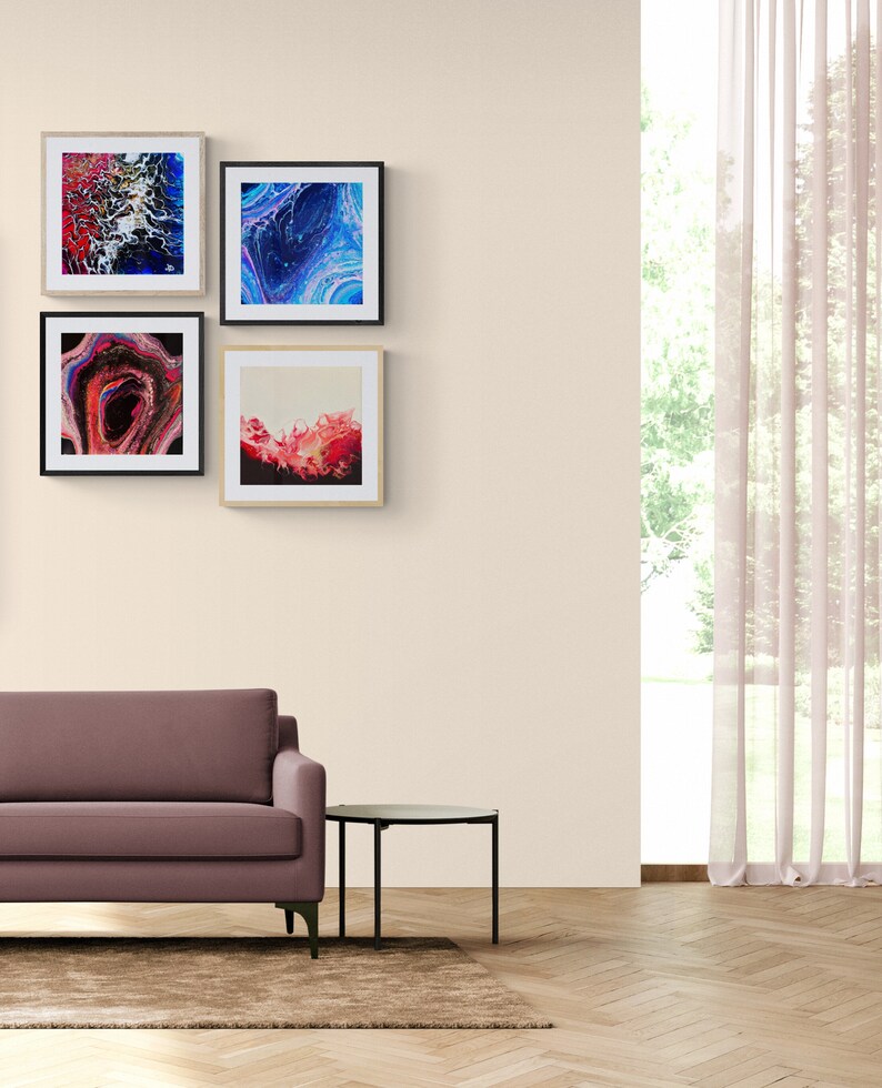May include: A living room interior with a mauve sofa, a black side table, and a brown rug. Four framed abstract paintings hang on the wall behind the sofa. The paintings feature blue, red, and white colours.