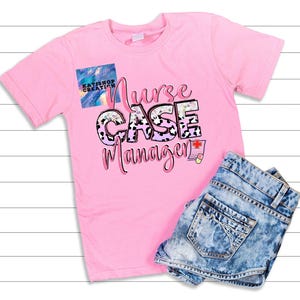 Pode incluir: Camiseta rosa com o texto "Nurse Case Manager" em letras rosa e pretas com um design de estampa de leopardo rosa e preto. A camiseta é combinada com shorts jeans azul claro.