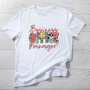 May include: White t-shirt with the text "Business Office Manager" in colorful letters with a leopard print design.