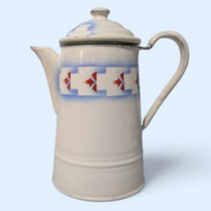 Puede incluir: Cafetera de esmalte color crema con tapa y asa. La cafetera presenta un diseño floral azul y rojo alrededor del centro y en la tapa. El pico está en el lado izquierdo. Aproximadamente 20 cm de alto.