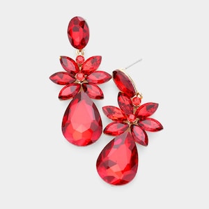 May include: A pair of red gemstone earrings. Each earring features a teardrop-shaped gem, a flower-shaped cluster of gems, and an oval gem at the top. The earrings have gold-colored metal accents and posts.