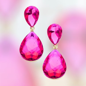 May include: A pair of pink teardrop-shaped dangle earrings with gold accents.
