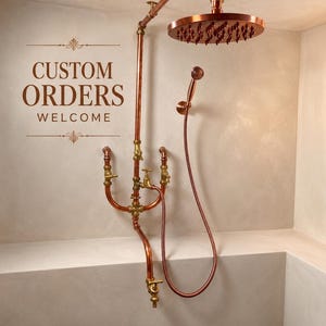 May include: Copper shower fixture with a round showerhead and handheld showerhead. The fixture has a vintage aesthetic with exposed pipes and brass fittings. The text "CUSTOM ORDERS WELCOME" is displayed on the wall.