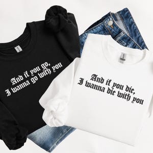 May include: Black and white long-sleeved shirts with the text "And if you go, I wanna go with you" and "And if you die, I wanna die with you" in a gothic font. The shirts are paired with blue denim jeans.
