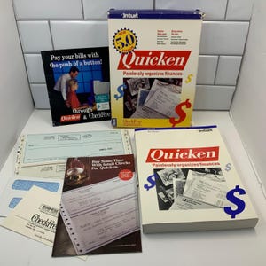 May include: A collection of vintage financial software and related materials. Includes a box and manual for Quicken 5.0, check samples, and promotional materials. The box and manual feature the text "Quicken Painlessly organizes finances."