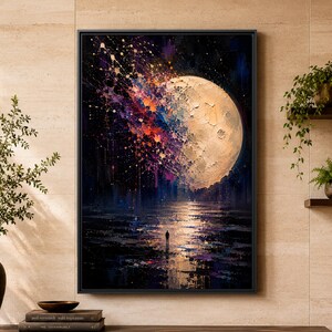 Puede incluir: Una impresión artística enmarcada que muestra una luna grande y texturizada en un cielo oscuro, con salpicaduras de pintura vibrante en morado, naranja y azul que se extienden desde la superficie lunar. Una pequeña silueta sobre una superficie.