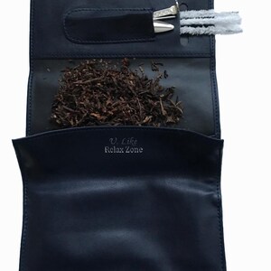 Puede incluir: Una bolsa de tabaco de cuero negro con cierre de cremallera. La bolsa tiene un bolsillo para una herramienta de tabaco y un compartimento separado para el tabaco. La bolsa tiene el texto "U. Like Relax Zone" impreso en la parte delantera.