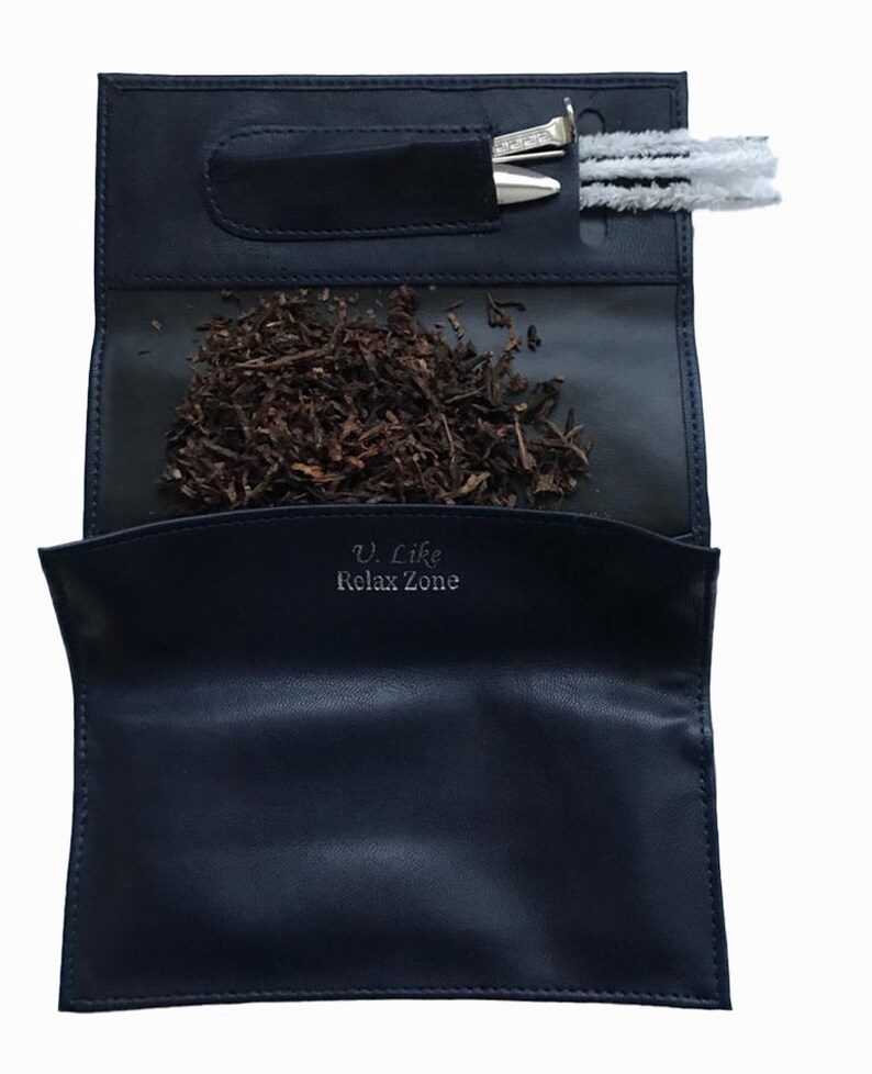 Puede incluir: Una bolsa de tabaco de cuero negro con cierre de cremallera. La bolsa tiene un bolsillo para una herramienta de tabaco y un compartimento separado para el tabaco. La bolsa tiene el texto "U. Like Relax Zone" impreso en la parte delantera.