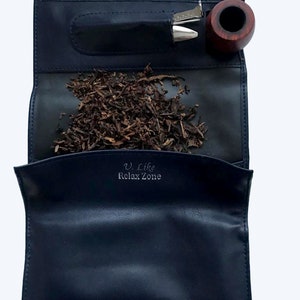 Puede incluir: Una bolsa de tabaco de cuero azul con una pipa, un tamp&oacute;n y tabaco en su interior. La bolsa tiene el texto "V. Like Relax Zone" impreso en la parte delantera.