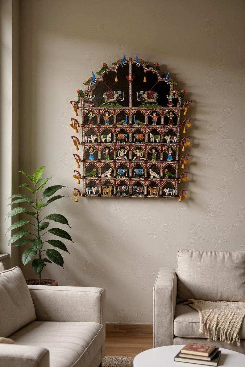 Puede incluir: Un gran adorno de pared arqueado con una estructura de madera de varios niveles sobre un fondo negro. Muestra numerosas figuras pintadas a mano de animales y personas en compartimentos individuales, acentuadas por peque&ntilde;as campanas amarillas.