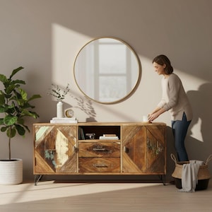 Könnte beinhalten: Ein rechteckiges Sideboard aus Holz mit zwei Seitenschränken mit Rautenmuster-Türen, zwei mittigen Schubladen und dünnen schwarzen Metallbeinen. Über dem Sideboard hängt ein großer runder Spiegel mit einem dünnen goldenen Rahmen.