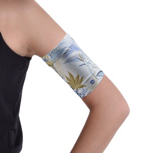 May include: A white arm sleeve with a blue and green floral pattern. The sleeve is made of a soft, stretchy material and is designed to protect your skin from the sun.
