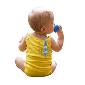 Può includere: Un bambino con una canotta gialla beve da una tazza blu. Un dispositivo medico con un tubo trasparente e un design blu e bianco è attaccato alla schiena del bambino. Il bambino è seduto.