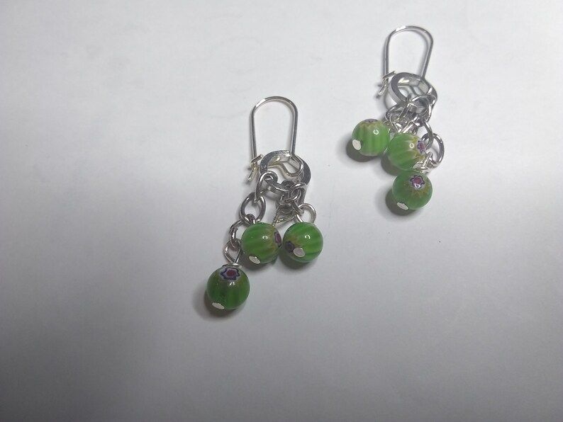 very cute Earrings with dangling round green beads with 3 with red and blue accents