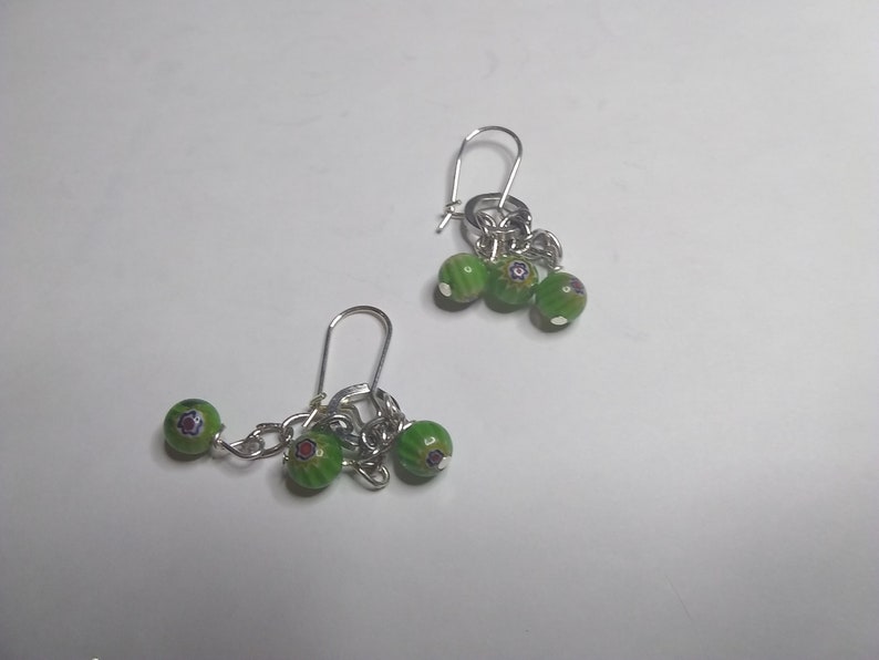very cute Earrings with dangling round green beads with 3 with red and blue accents